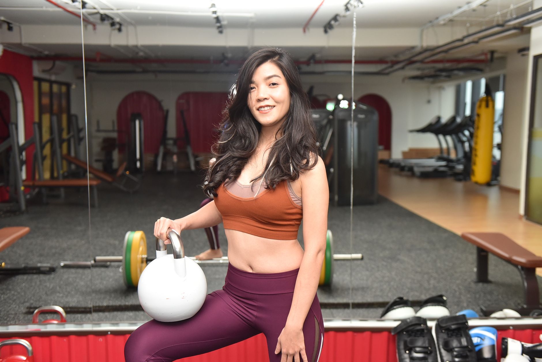 Woman doing a kettlebell workout in a bright room